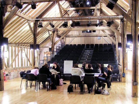 interior of theatre space with chairs and people working