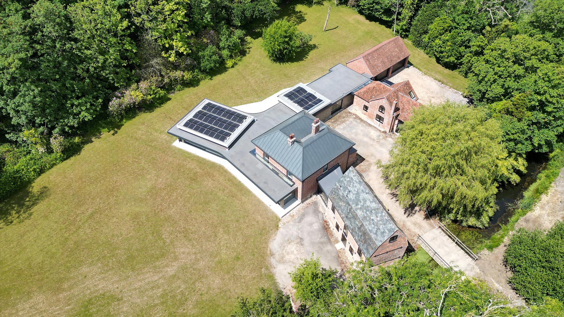 aerial view of large listen house with modern extension and solar panels on roof