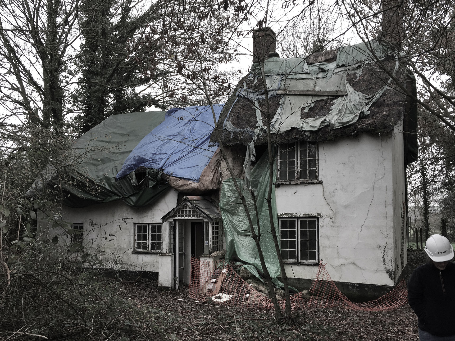 before photo of dilapidated thatched roof house