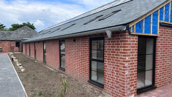 single storey red brick building under construction