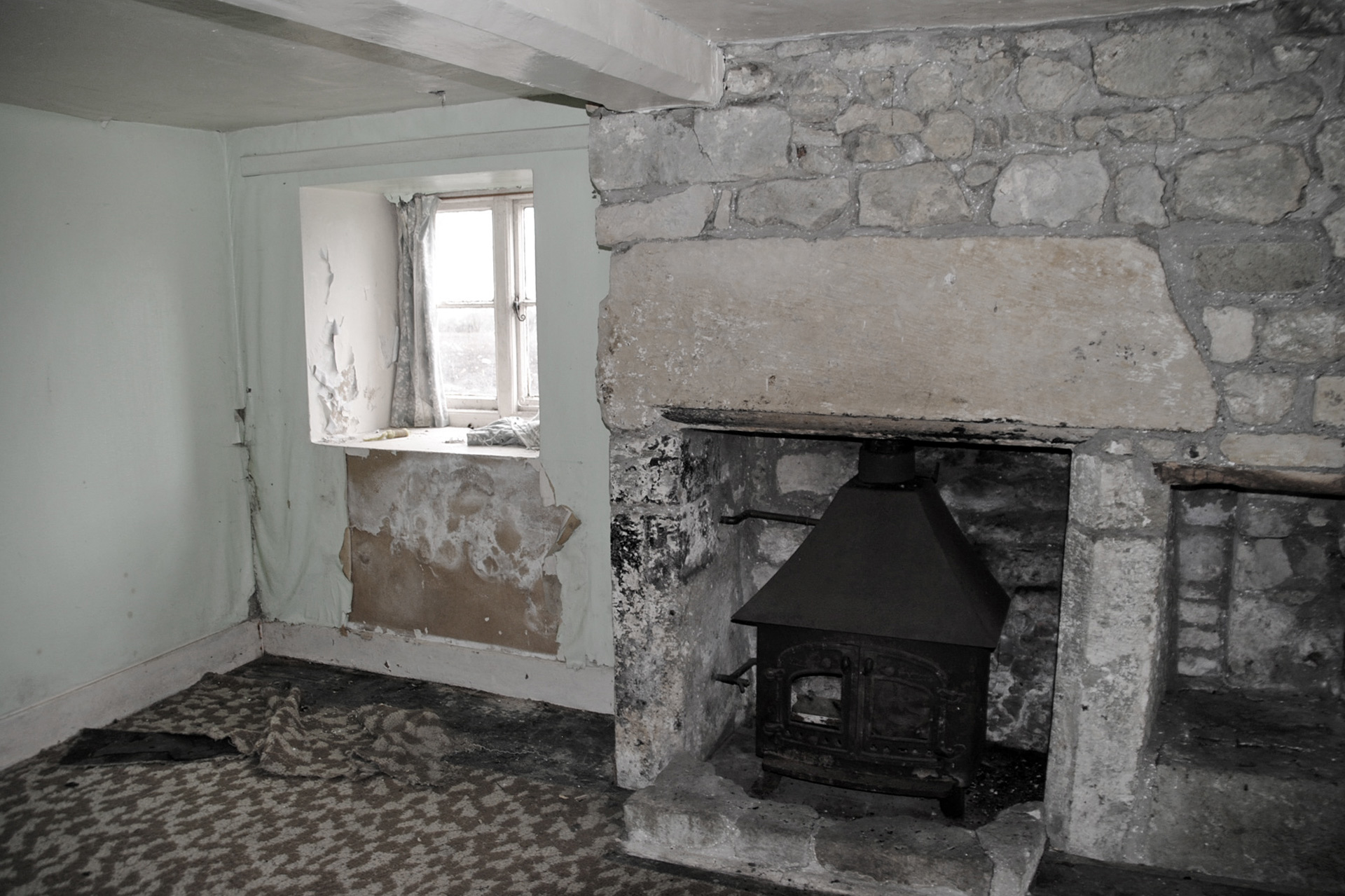 before photo of wood burner fireplace with stone wall