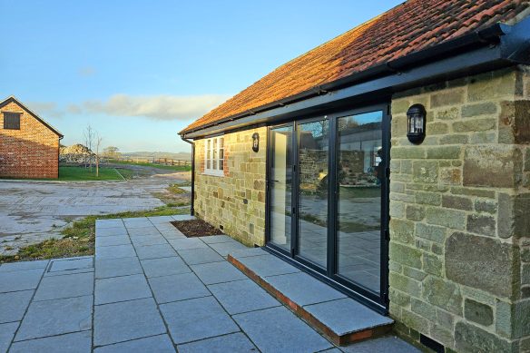 stone garage with glass doors and red tiled roof