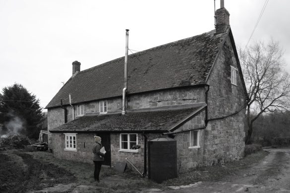 rear view before photo of stone house with tiled roof