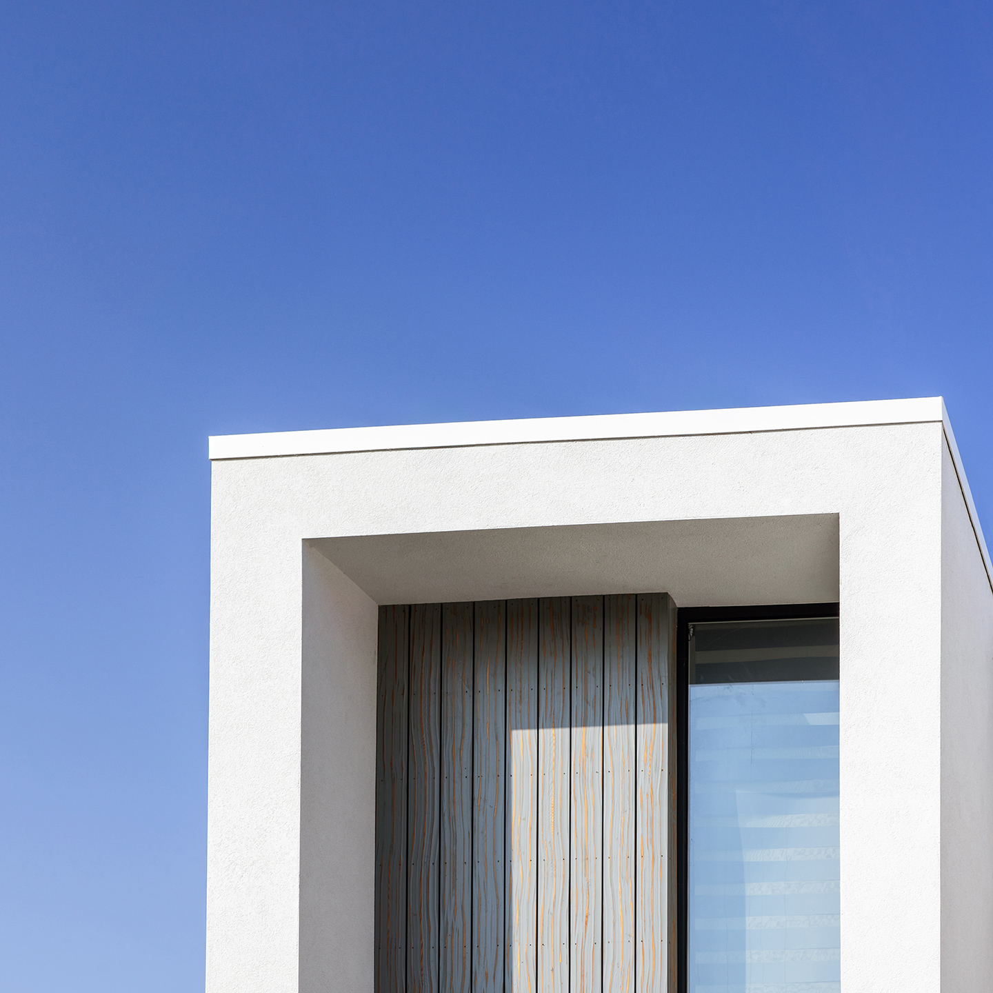 detail view of contemporary house with white render