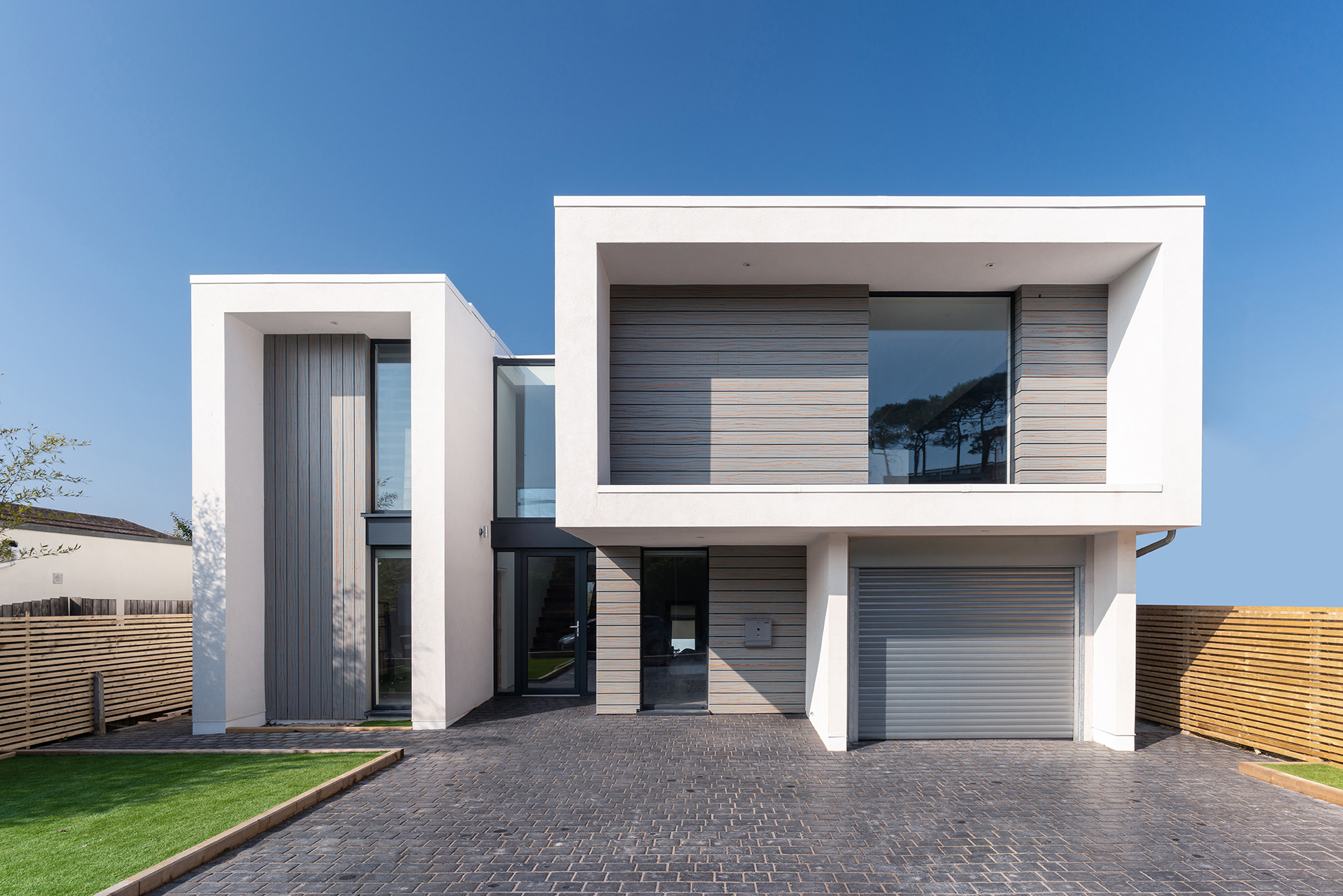 entrance view to modern white house with geometric design and driveway