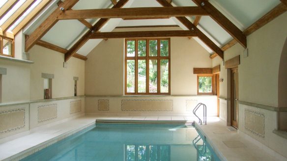 indoor swimming pool with vaulted ceiling and exposed timber frames