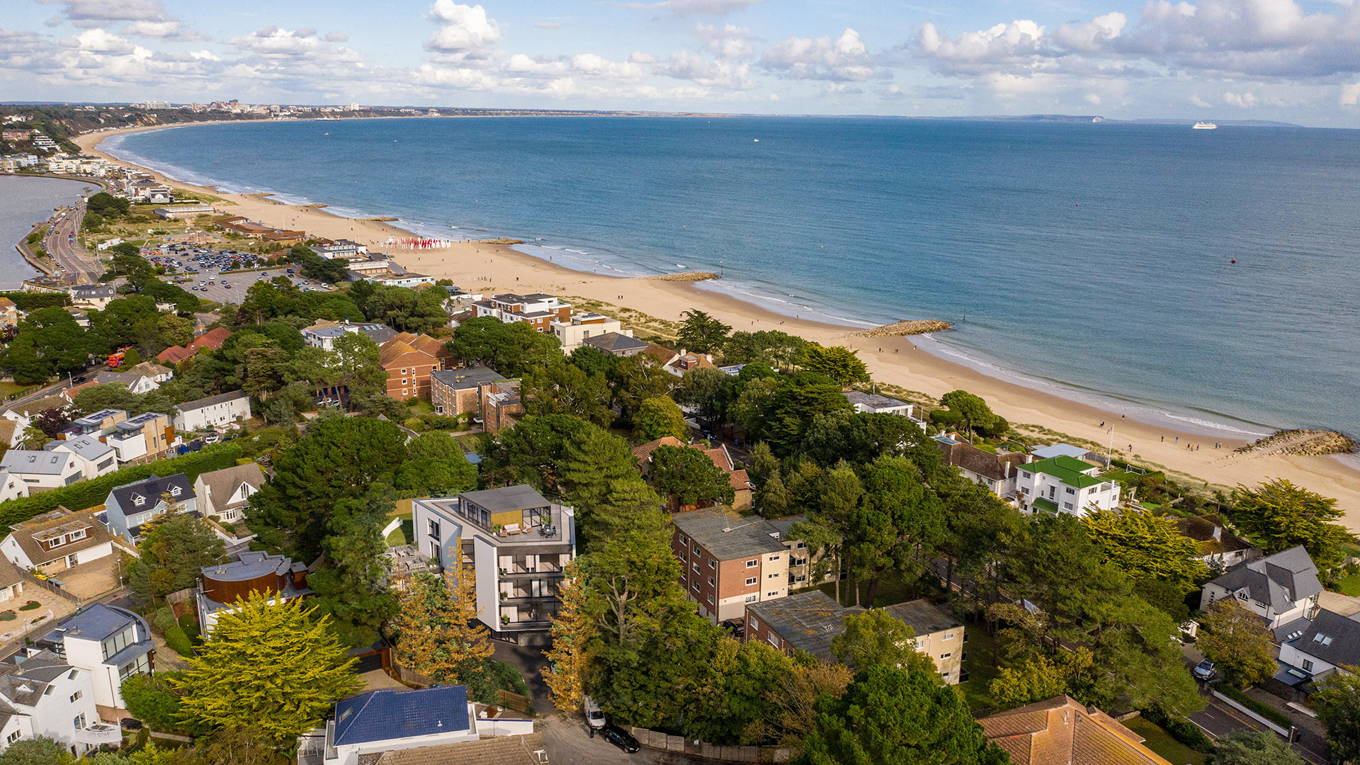 aerial view of houses and sea with CGI of contemporary new apartments