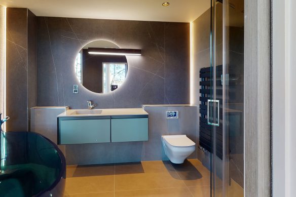 modern bathroom with freestanding blue glass bath