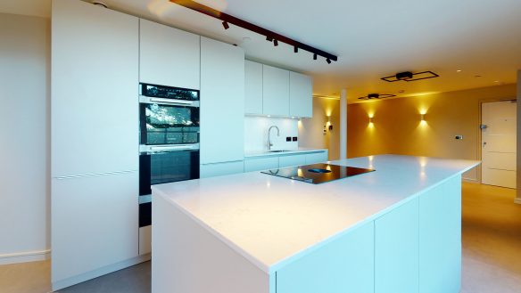 Contemporary kitchen in white tones with kitchen island with feature wall lights