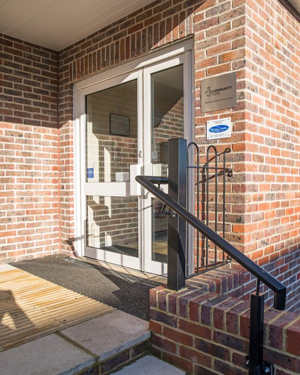 steps leading up to village hall entrance with red brick wall