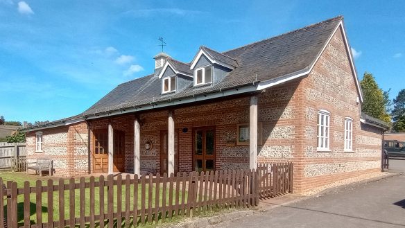 village hall with red brick and veranda leading to entrance