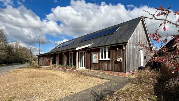 village hall with aged timber cladding and solar panels on roof