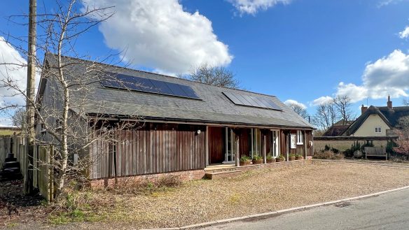 village hall with aged timber cladding and solar panels on roof