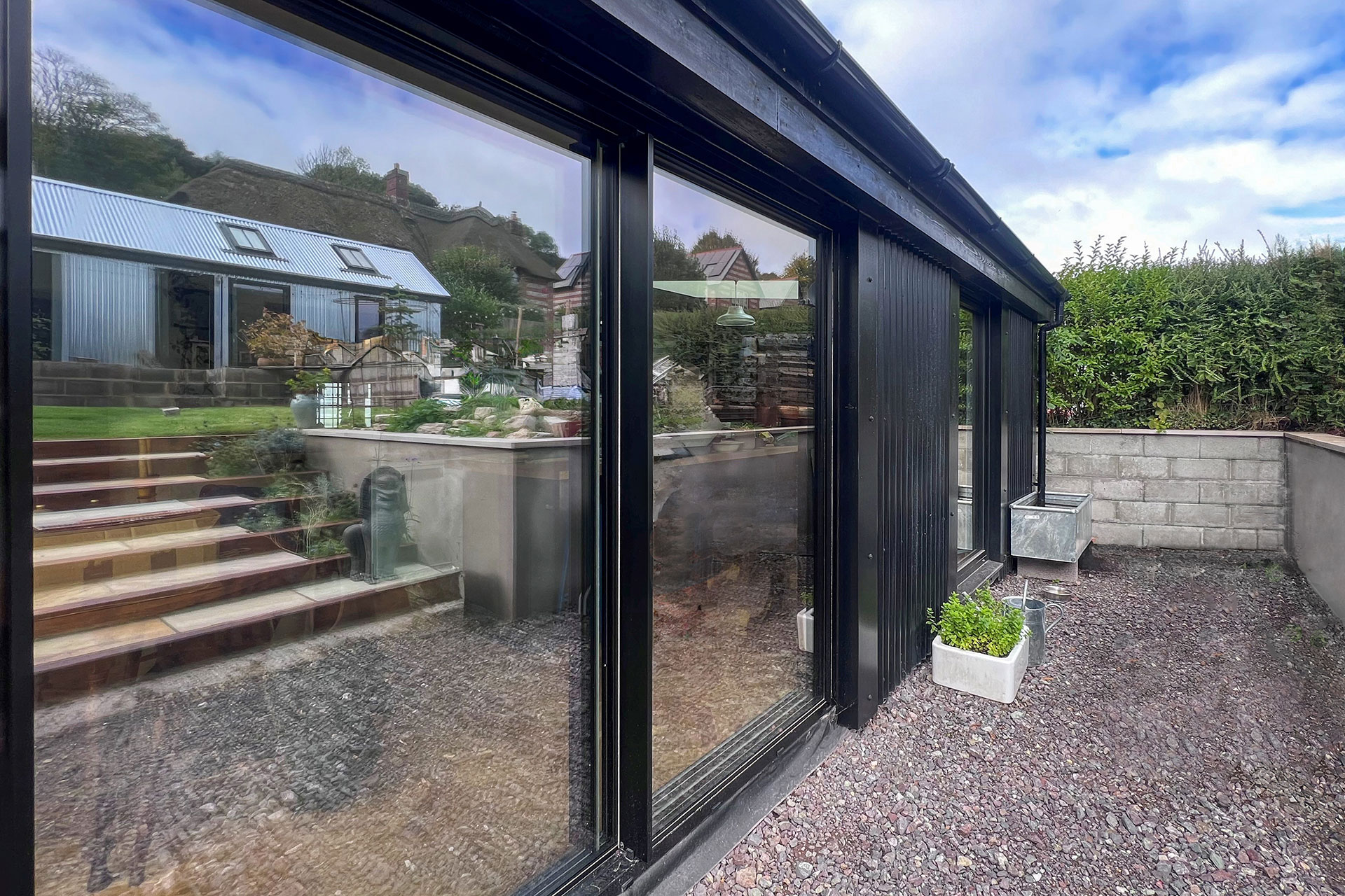 modern extension to cottage with large window and sliding doors