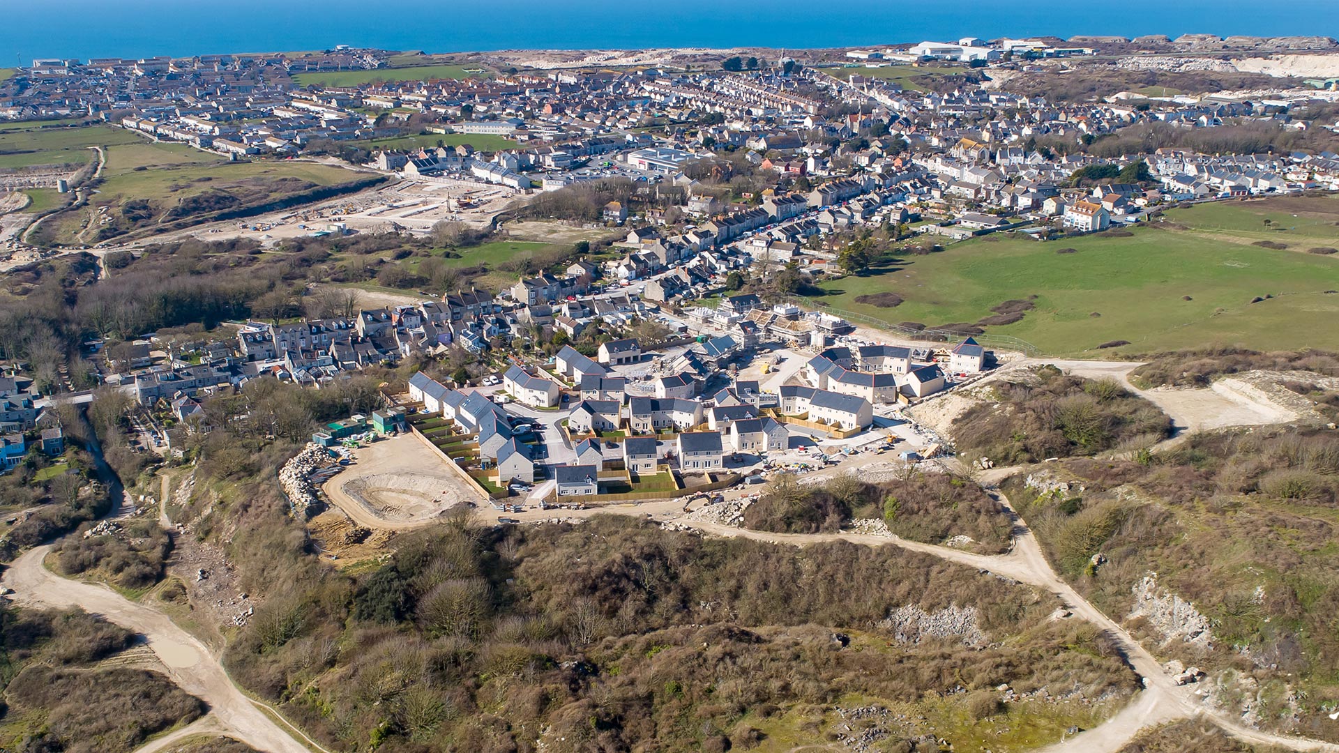 aerial view of new housing development with sea in distance