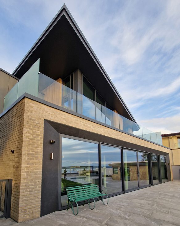 rear view of modern house with large patio sliding doors and balcony