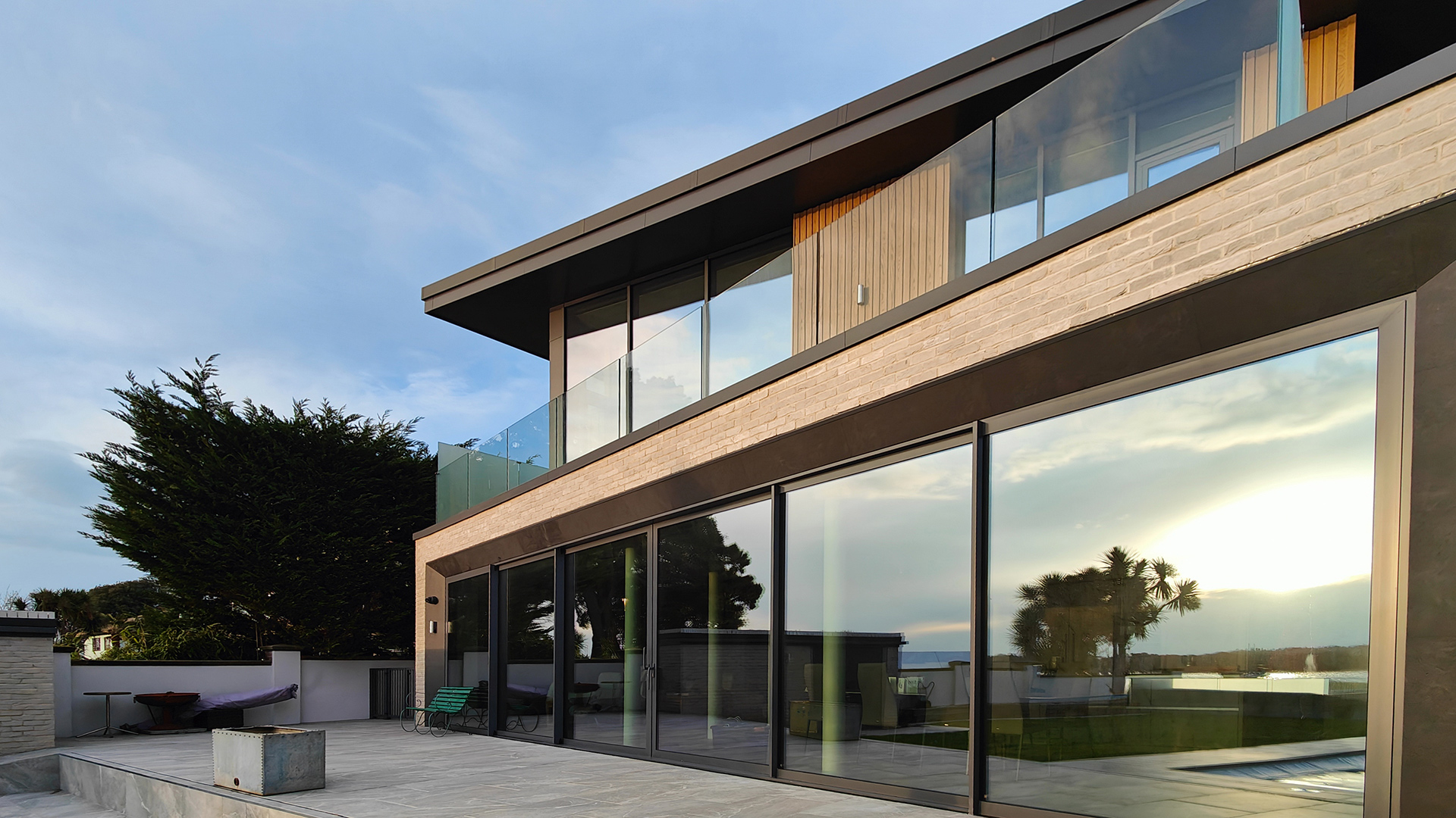 rear view of modern house with large patio sliding doors and balcony