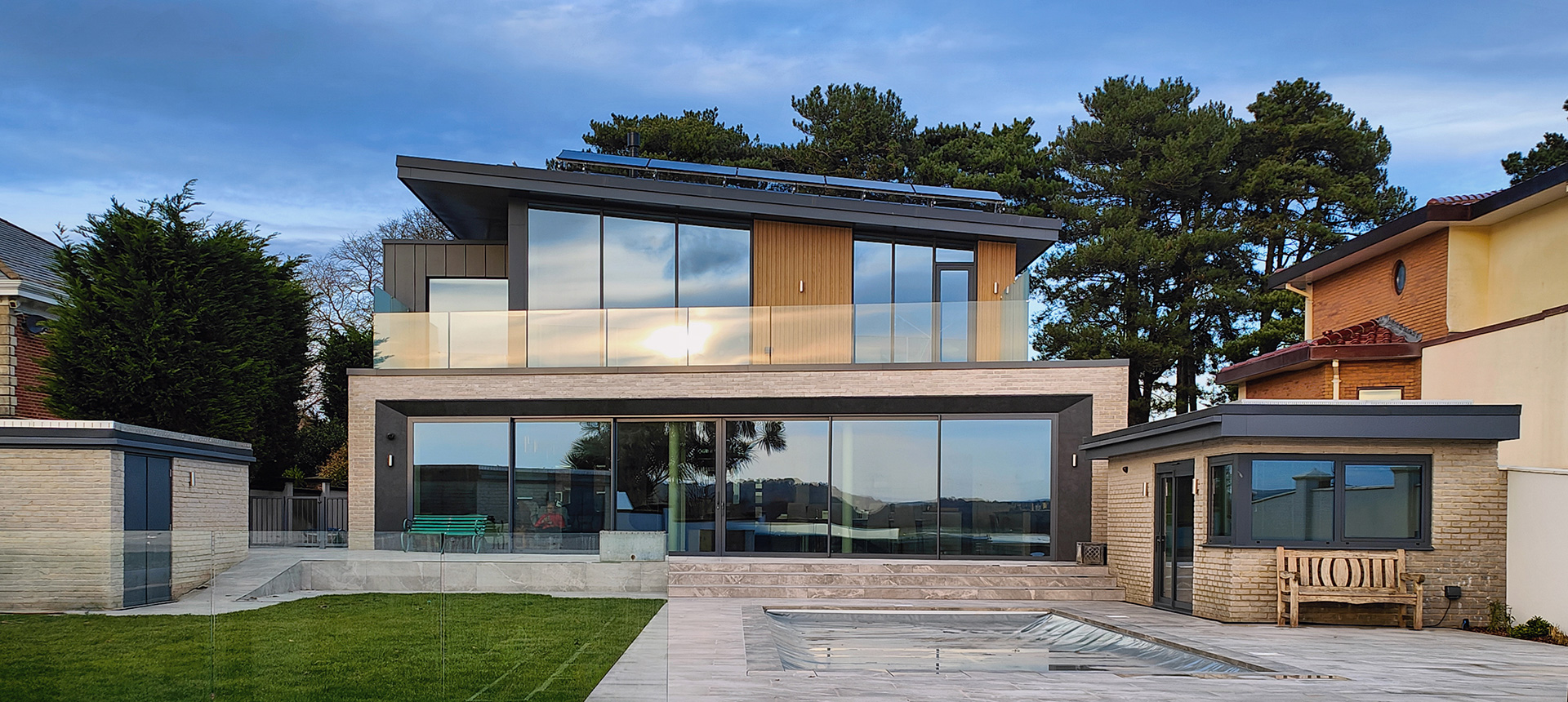 rear view of modern house with large patio sliding doors and swimming pool