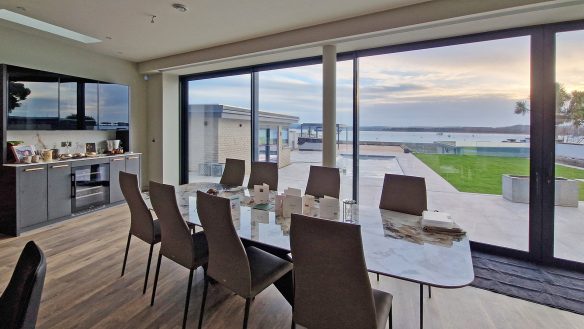 dining area with patio doors with beautiful sea views and garden with swimming pool